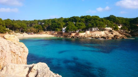 Strand in Mallorca, umgeben von Felsen und klarem Wasser sowie der Natur im Hintergrund
